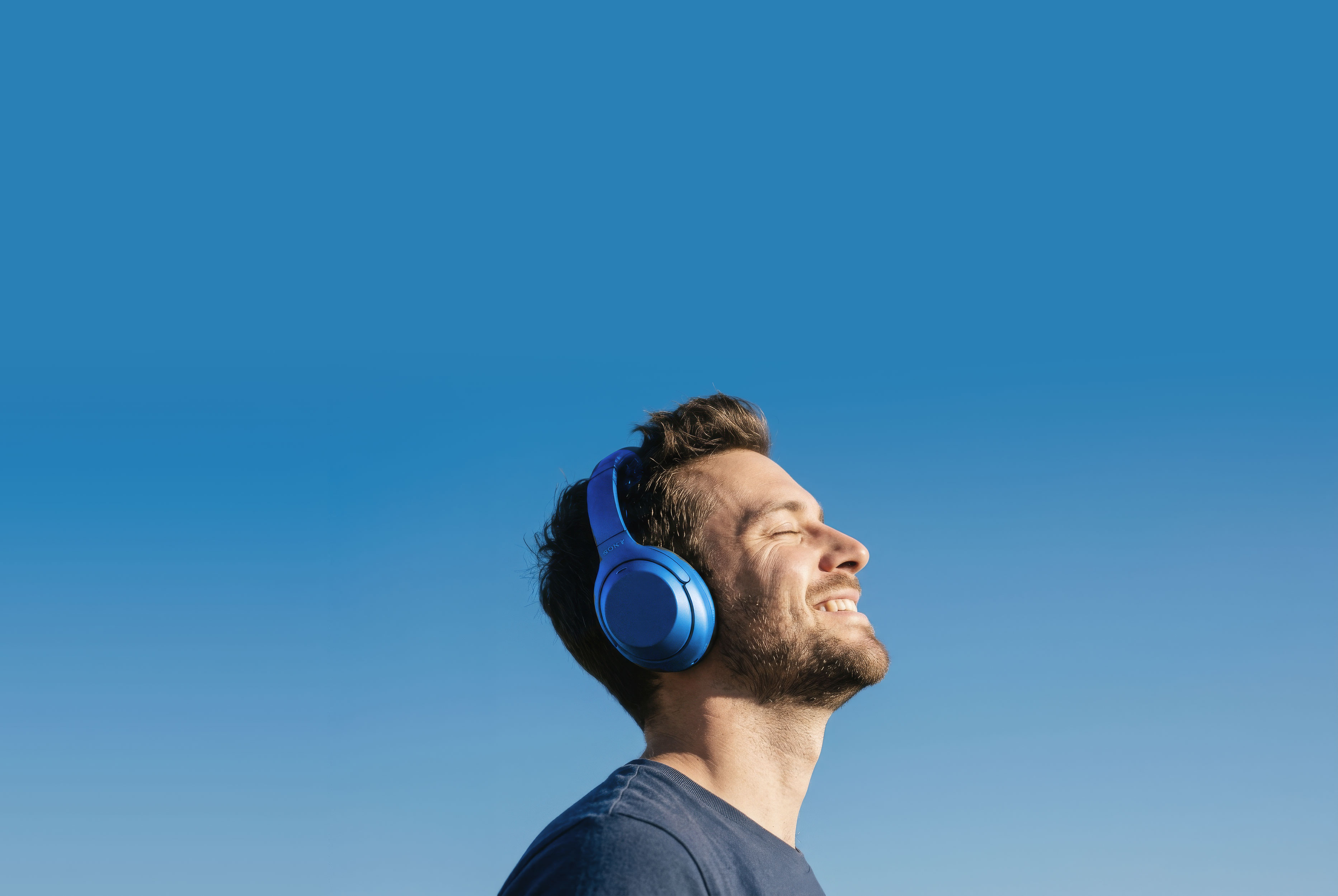 Man with headphones enjoying sunlight in profile